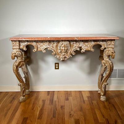 MARBLE TOP HALL TABLE | Italian Rococo hall/console table with a variegated marble top resting on four ornately carved legs; made in...