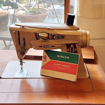 Vintage Singer Slant-O-Matic sewing machine in cabinet.