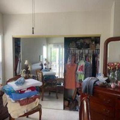 stuffed closet of womens clothing, long dresser with mirror, matching queen sleigh bed frame, 2 night stands and tall dresser