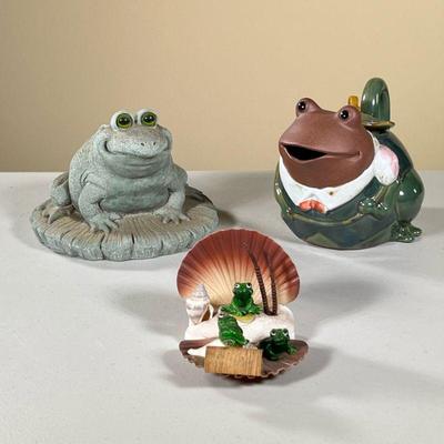 (3PC) FROG CERAMICS | Including smiling frog on lily pad, frog in a suit teapot, and 3 small frogs in a seashell. - l. 8 x w. 5.5 x h....