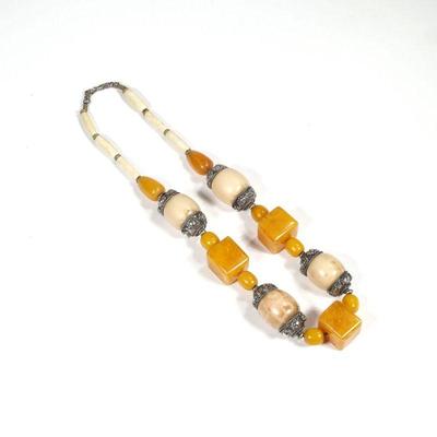 UNUSUAL CARVED BONE & AMBER NECKLACE | Having four oval carved bone links (26mm) with silver mounts alternating with three cube-form...