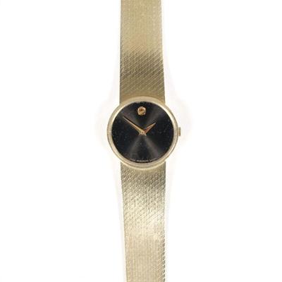 MOVADO WOMAN'S 14K GOLD WRISTWATCH | Black dial with gold dot numeral, 14k and with swiss hallmarks, s/n 1143002. 37.0g, l. 7 in.

