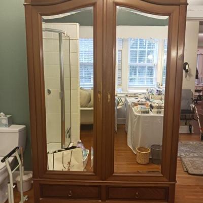 Stunning large antique armoire with beveled mirror double doors and two drawers.