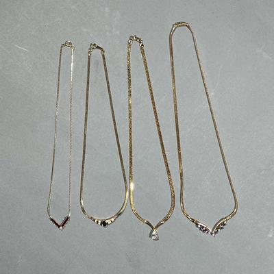 (4PC) ELEGANT COSTUME NECKLACES | Gold-toned costume necklaces with faux gemstones, including an unmarked necklace with a teardrop faux...
