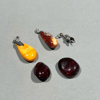 (4PC) AMBER PENDANTS | Including two butterscotch amber pendants with sterling silver leaf-form mounts/bails, with one additional bail;...