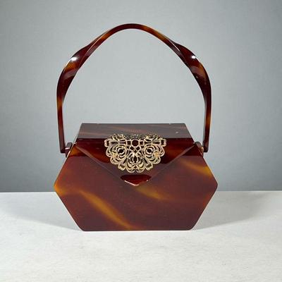 WILLARDâ€™S LUCITE BAG | 1950s Bakelite style lucite handbag with interior mirror and decorative metal mounting; height with handle 9.75...