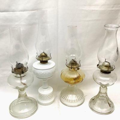 BIHY819 Oil Lamps	Collection of four oil lamps. Three have glass bases, one has a ceramic base. Tallest measures in at approximately...
