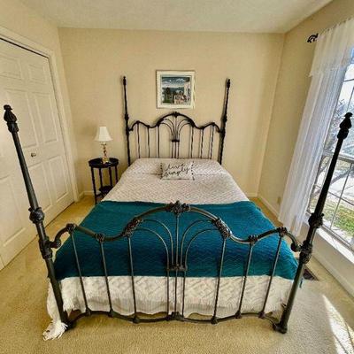 Lot 014-BR1: Bedroom 1 Vignette

Features: 
â€¢	Iron queen bed frame with head- and footboard
â€¢	Replica antique side table
â€¢	Brass...