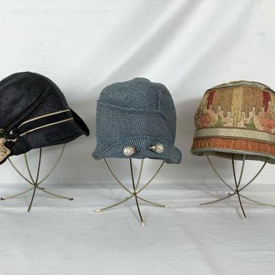 BIHY204 1920â€™s-1930â€™s Cloche Hat Trio	Black with a black and tan ribbon with a flower design on the side of the hat.
