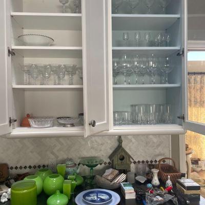 Multiple sets of =crystal and glass ware. Everyday and stemware. Bright green assorted table top decor. 