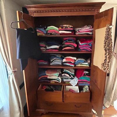 ARmoire interior and lots of shirts and sweaters
