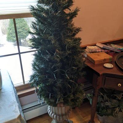 Prelit Christmas tree in faux stone urn