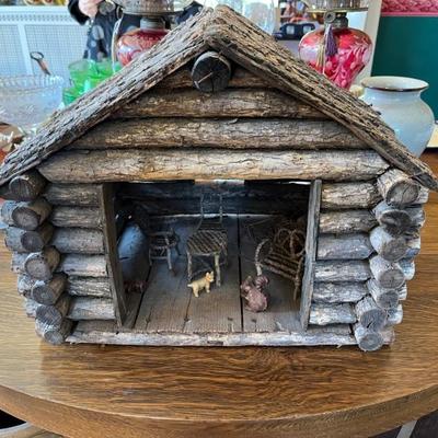 1920s folk art log cabin with furniture and wooden animals