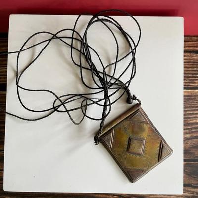 North African brass pendant with geometric designs and a shackled jinn