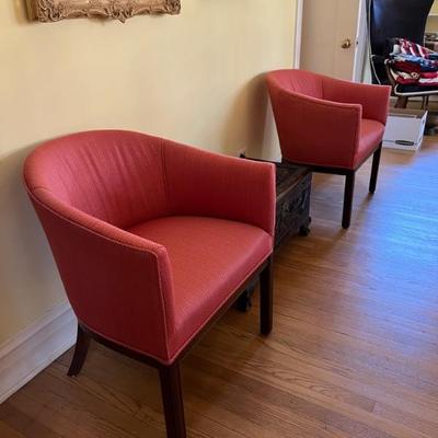 a pair of vintage club style chairs covered in a pretty raspberry red