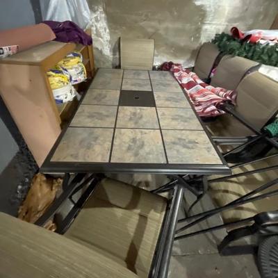 $375 Like new tile top patio set with six chairs and umbrella. Table measures 40 x 64.