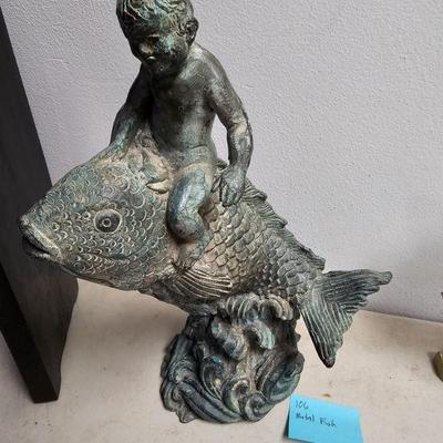 bronze boy riding fish sculpture