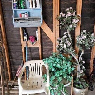 #10002 â€¢ Plastic Chair with End Table, Fake Plants and Shelf with Cleaning Products
