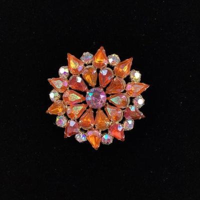 BIHY102 Vintage Rhinestone Brooch	This is a beautiful vintage rhinestone brooch. The brooch features vibrantly iridescent orange and...