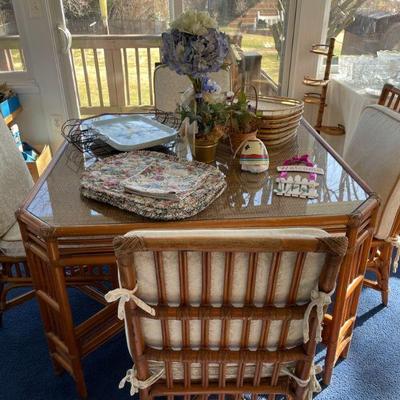 Rattan glass-top table with four matching rattan chairs.