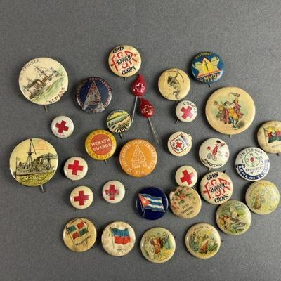 Lot 68 | Vintage Pinbacks. Includes several American Red Cross pins, pins of different countries and US ships, Disney Pinocchio, and...