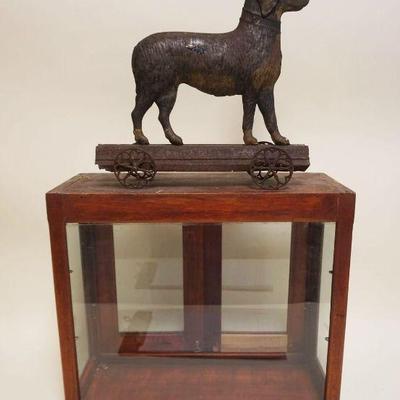1153	ANTIQUE CHILDS VICTORIAN METAL DOG PULL TOY IN DISPLAY CASE, APPROXIMATELY 8 IN X 20 IN X 18 IN OVERALL
