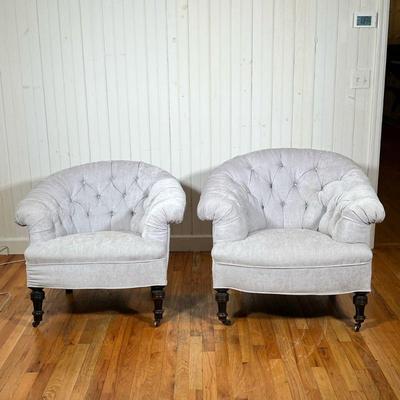 PAIR TUFTED BARREL BACK ARMCHAIRS | Tub chairs having tufted barrel backs low form with turned legs on castors. 