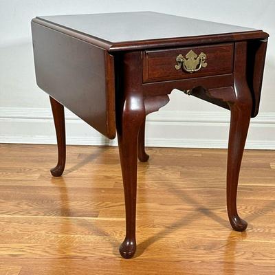 BASSETT DROP LEAF SIDE TABLE | Having mahogany finish and two drop leaves on either side with single drawer over cabriole legs, leaf...