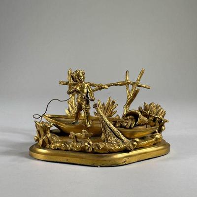 LAD FISHING DESK ORNAMENT | Depicts a small shirtless boy net fishing from a boat among the reeds
