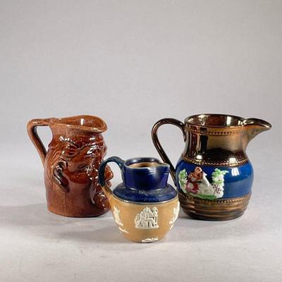 (3PC) MINIATURE CERAMIC PITCHERS | Includes: Copper ceramic pitcher, pitcher decorated with Colonial imagery, and bust pitcher.