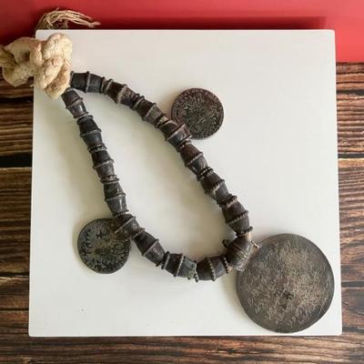 Omani silver pendant on a necklace with large silver beads and two 18th century coins on a thick cord