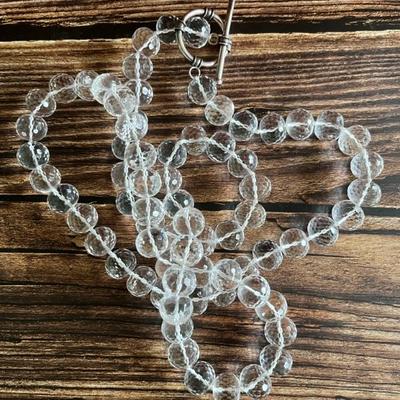 Long, clear faced crystal beaded necklace with a silver clasp