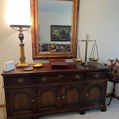 traditional style wood sideboard with a large gold mirror