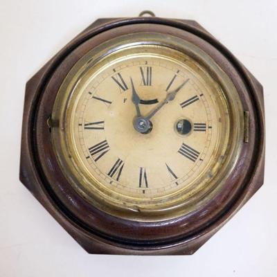 1029	ANTIQUE MINIATURE WALL CLOCK IN OCTAGON WALNUT CASE, APPROXIMATELY 7 IN
