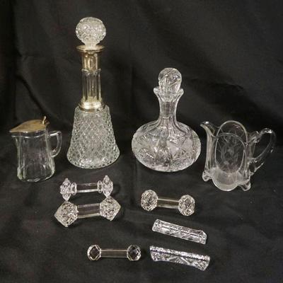 1055A	GROUP OF ASSORTED CRYSTAL GLASS DECANTORS, KNIFE RESTS, SYRUPS, ETC, LARGEST PIECE APPROXIMATELY 13 1/2 IN HIGH
