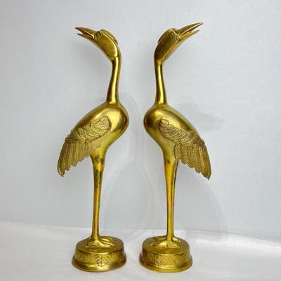 A pair of stunning vintage brass crane statues, tall and slender figurines feature intricate feather detailing and a graceful posture...