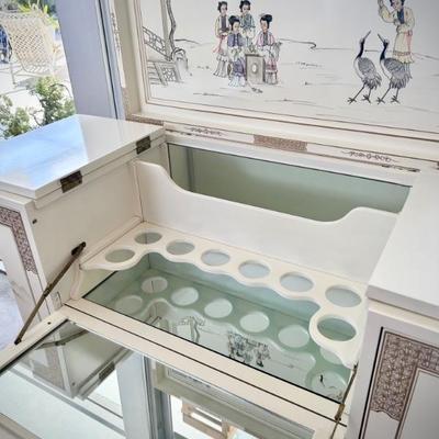 Ivory chinoiserie pulldown wet bar. Both sides open to hold wine glasses, bottom opens to hold bottles, and top opens for bar. 