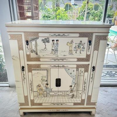 Ivory chinoiserie pulldown wet bar. Both sides open to hold wine glasses, bottom opens to hold bottles, and top opens for bar. 