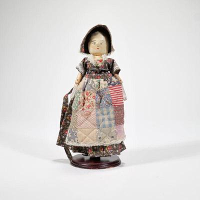 ANTIQUE WOODEN DOLL | Hand-painted and carved wooden doll with quilt apron and articulating arms - l. 5 x w. 2 x h. 11 in.
