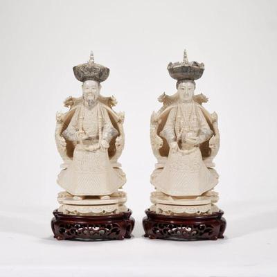 PAIR ANTIQUE CHINESE FIGURAL CARVINGS | 19th century, carved ivory figures of a man and woman in traditional robes, seated in matching...