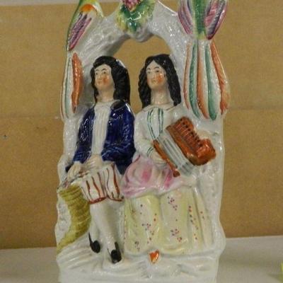 Staffordshire couple with accordion in arbor with parrots
