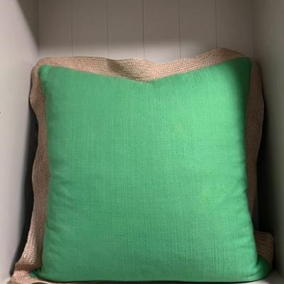 A large vivid green linen pillow with burlap as trimmings.