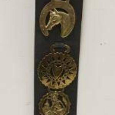1035	BRASS HORSE MEDALIONS, GROUP OF 10 MOUNTED ON LEATHER STRAP
