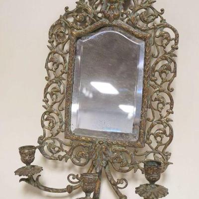 1007	ORNATE BRASS  WALL HANGING MIRROR W/CANDLE SCONCE & EMBOSSED GROTESQUE MASK, SOME LOSS TO MIRROR SILVERING, APPROXIMATELY 11 IN X 18...