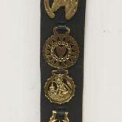 1032	BRASS HORSE MEDALIONS, GROUP OF 10 MOUNTED ON LEATHER STRAP
