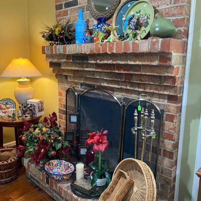 Mantel full of collectibles including Talavera jug, fireplace screen and tools