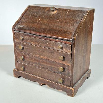 MINIATURE CHIPPENDALE DESK | Drop front desk with four drawers, brass pulls in stained pine. - l. 7.25 x w. 4.75 x h. 8 in

