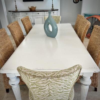 White painted dining table with - can sit 8-10 people with leaf in it. Six sisal/rattan chairs and two upholstered green chairs.