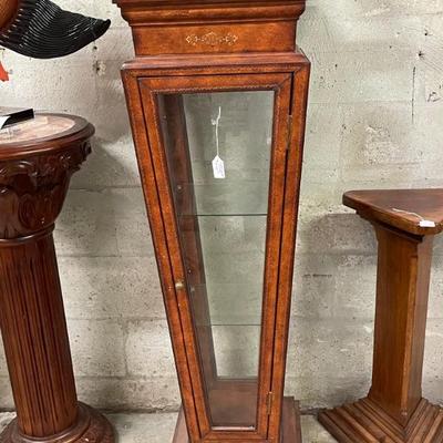 Leather like finish art pedestal stand with glass door, sides and shelves for additional display