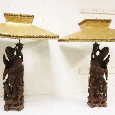 1055	PAIR OF MASSIVE CARVED WOODEN ASIAN FIGURAL TABLE LAMPS, BOTH HAVE AGE CRACKS, EACH APPROXIMATELY 41 IN HIGH

